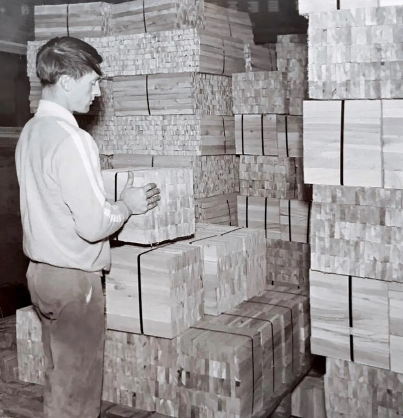 Old photograph of a man stacking wood for cedar flats.